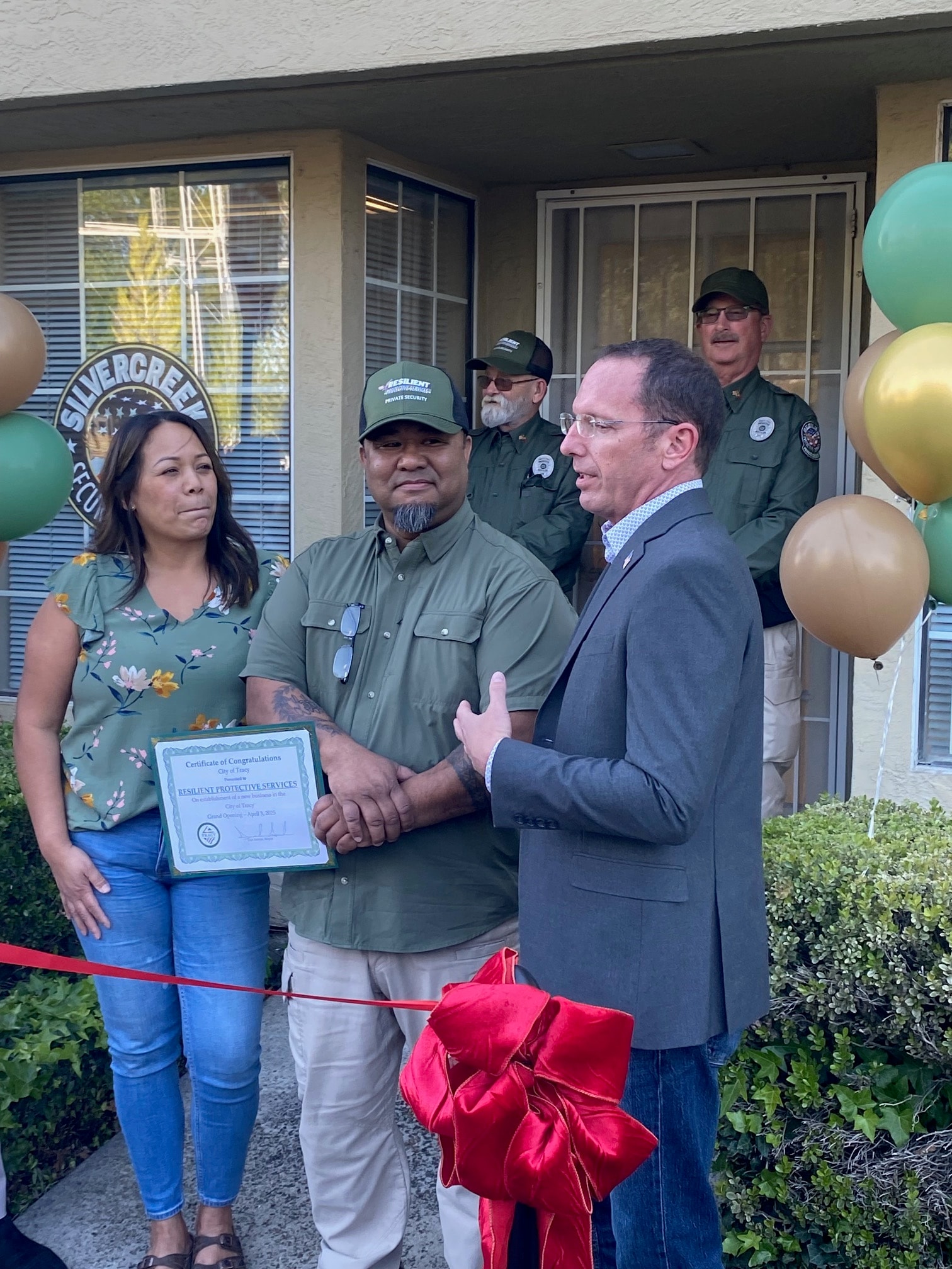 Dan Evans presenting a certificate of congratulations at a ribbon cutting
